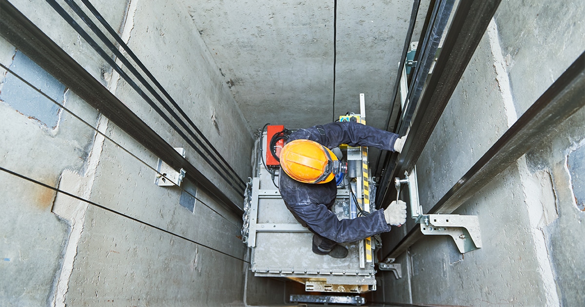 Techniker bei der Arbeit im Aufzugsschacht