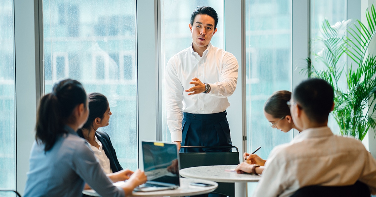 Vier Personen hören einer Person zu, die einen Workshop gibt