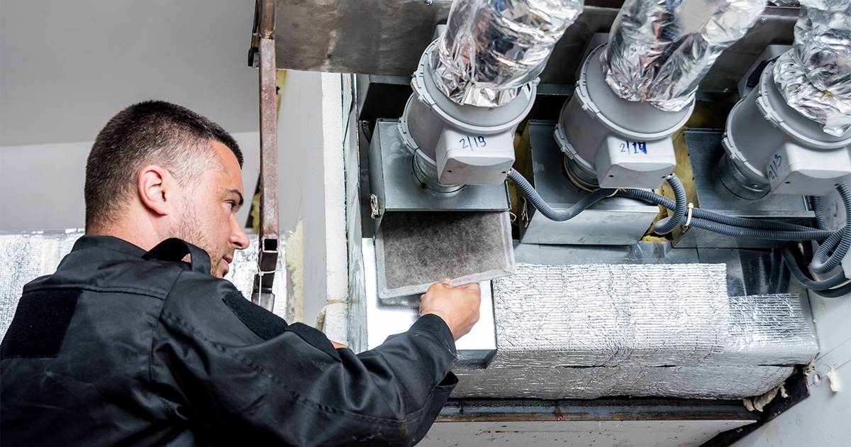 Technician changing air conditioner filter