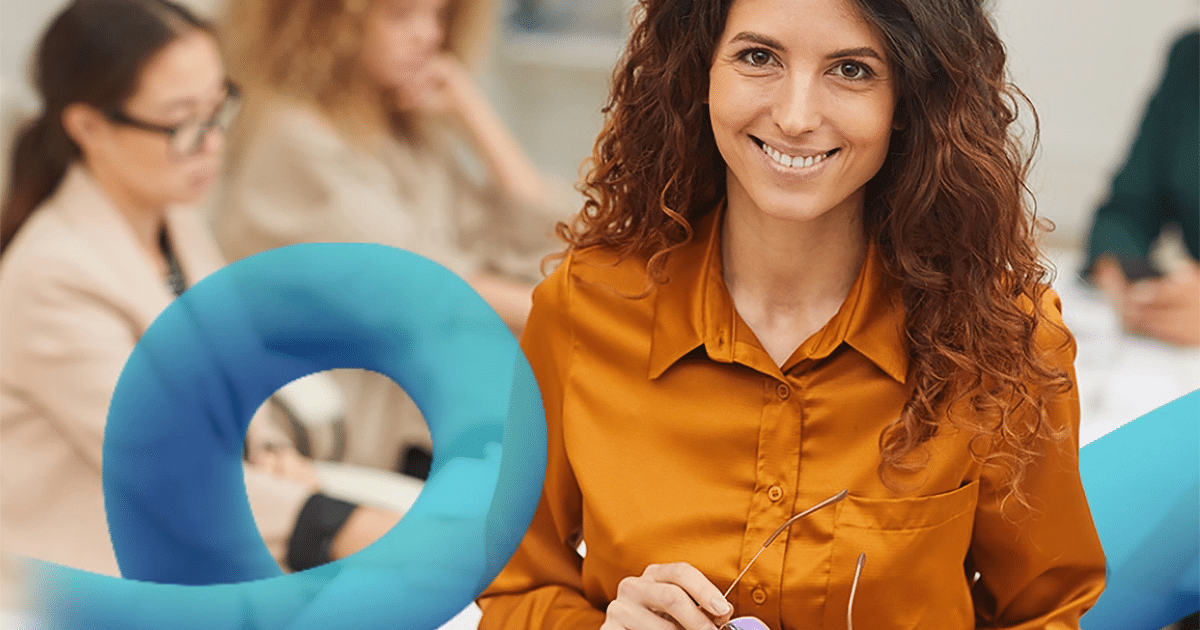 A person smiling with glasses in her hand