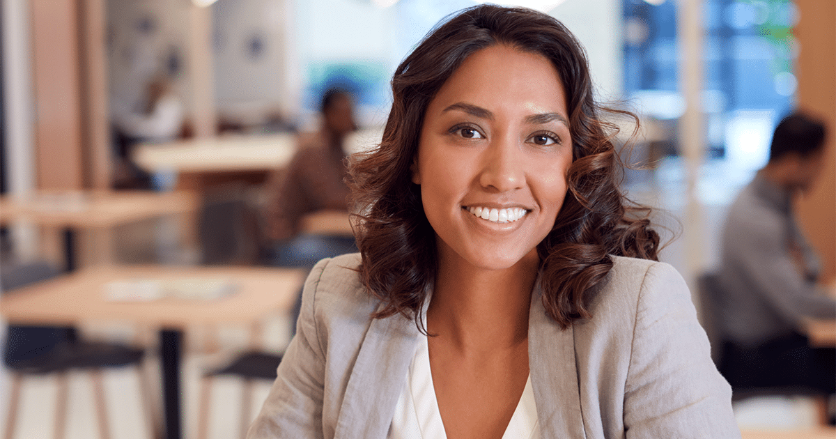 Lady sitting at desk smiling.