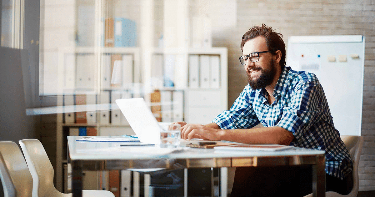 Person with beard working on laptop